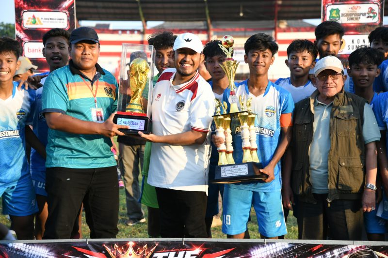 Bupati Sumenep Dr. Achmad Fauzi Wongsojudo (kanan) saat menyerahkan Tropi AF Sport kepada Camat Pasongsongan, Aynizar Kusuma